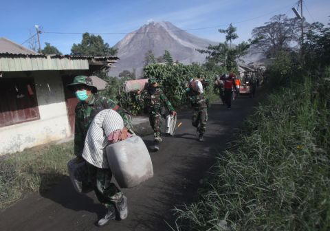 Indonesian soldiers carry people's belongings during an evacuation Sunday, May 22.