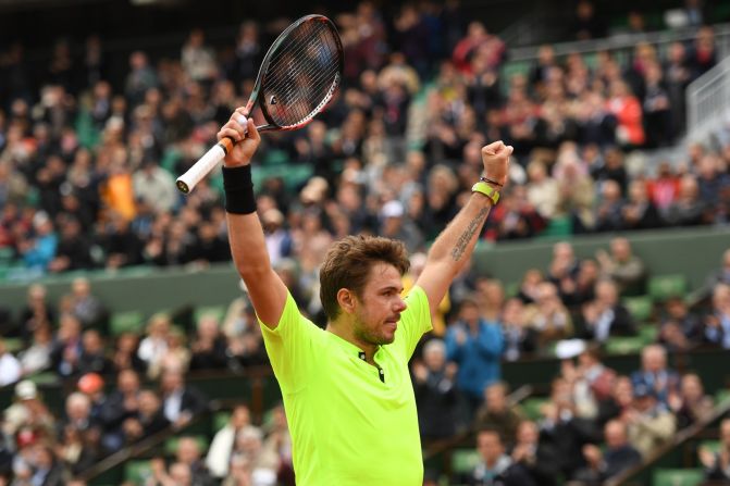 Stan Wawrinka raises his arms in celebration after seeing off Lukas Rosol in five sets in the first round. 