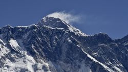 This photograph taken on April 20, 2015 shows a view of Mount Everest (C-top) towering over the Nupse, from the village of Tembuche in the Khumbu region of northeastern Nepal.  Sherpas, thought to be of Tibetan origin, have a long and proud history of mountaineering, and the term today is used for all Nepalese high-altitude porters and guides assisting climbing expeditions around Everest. The April 25 quake, which left more than 7,800 people dead across Nepal, was the Himalayan nation's deadliest disaster in over 80 years, and triggered an avalanche which killed 18 people on Everest, leading mountaineering companies to call off their spring expeditions, marking the second year with virtually no summits to the roof of the world.      AFP PHOTO / ROBERTO SCHMIDT        (Photo credit should read ROBERTO SCHMIDT/AFP/Getty Images)