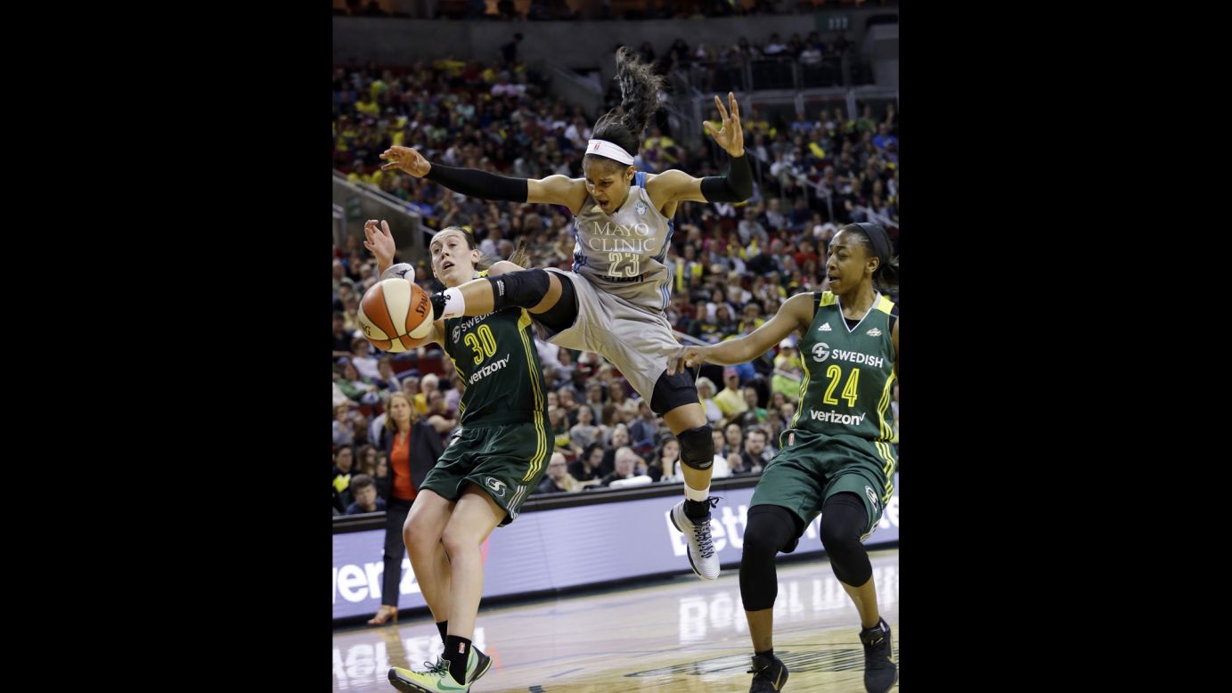 Minnesota's Maya Moore, center, loses the ball as she drives between Seattle's Breanna Stewart, left, and Jewell Loyd during a WNBA game on Sunday, May 22. All three players were No. 1 overall picks in the WNBA Draft.