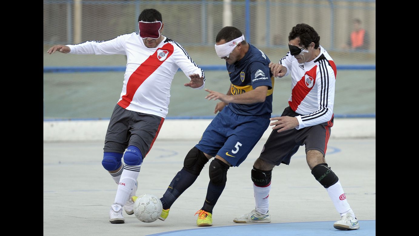 Boca Juniors' Silvio Velo, center, competes against River Plate's Daniel Vega, left, and Oscar Mouzo during a blind-soccer match in Buenos Aires on Saturday, May 21. In blind soccer, the teams are made up of four visually impaired outfield players wearing blindfolds. The goalkeeper does not wear a blindfold, and he or she may be fully sighted. The ball is designed to make a sound when it moves.
