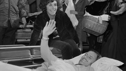 Oct 1969: An incapacitated Hill returns home to the UK from the U.S. alongside wife, Bette (C).