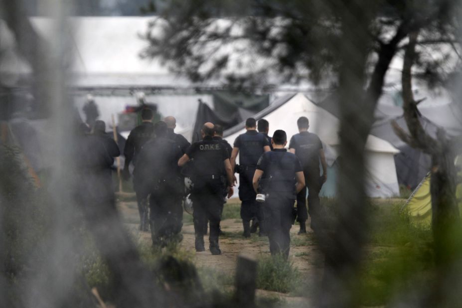Greek policemen walk into a makeshift camp at the Greek-Macedonian border near the northern village of Idomeni on Tuesday, May 24.