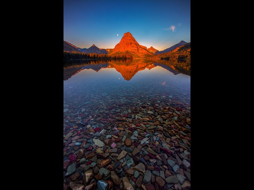 Manish Mamtani made a pre-dawn mission to Two Medicine Lake, Glacier National Park, Montana, to capture this sunrise. "There were no clouds but the lake water was so calm, it created a perfect reflection of the red light kissing the Sinopah Mountain," he says. (<a href="http://travel.nationalgeographic.com/photographer-of-the-year-2016/" target="_blank" target="_blank">Click here to enter NatGeo photo contest</a>)