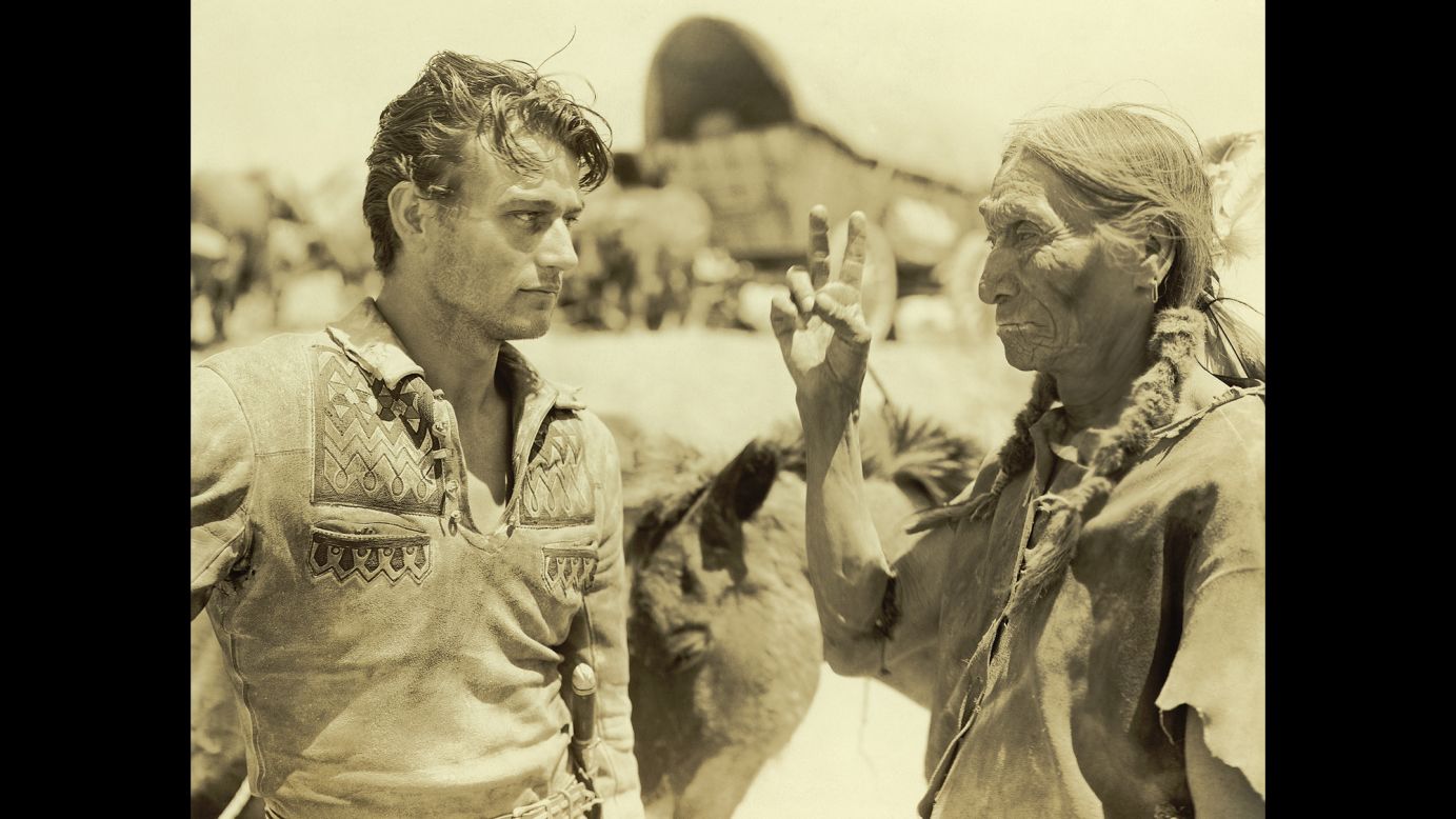 Wayne talks to a Native American on the set of the 1930 movie "The Big Trail." It was Wayne's first starring role.