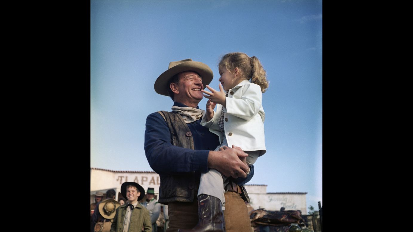 Wayne holds his daughter Aissa on the set of "The Alamo."