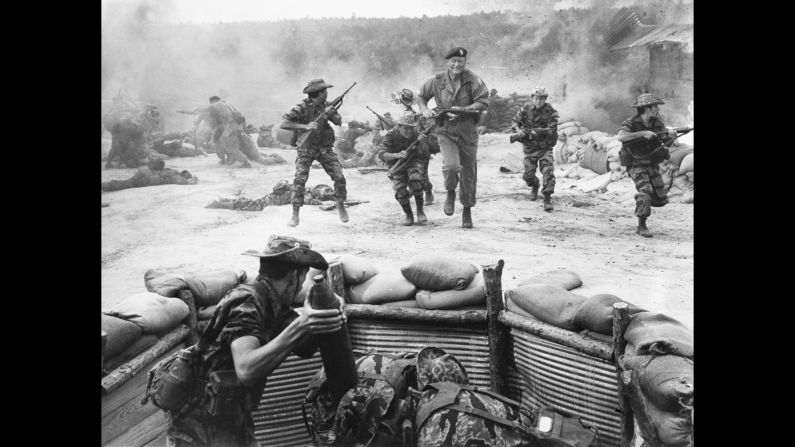 Wayne takes cover during an action scene in the 1968 film "The Green Berets."