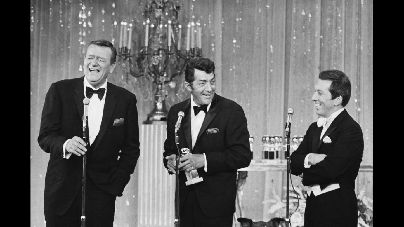 Wayne laughs on stage with singer Dean Martin, center, and host Andy Williams during the Golden Globe Awards in 1967.