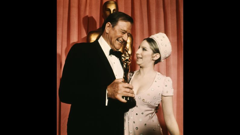 Wayne stands next to actress Barbra Streisand after winning the best actor Oscar in 1969. He won the award for his role as U.S. Marshal Rooster Cogburn in "True Grit." "Ladies and gentleman, I'm no stranger to this podium," he said in <a href="index.php?page=&url=https%3A%2F%2Fwww.youtube.com%2Fwatch%3Fv%3D7qQhODwivLU" target="_blank" target="_blank">his acceptance speech.</a> "I've come up here and picked up these beautiful golden men before, but always for friends. ... I feel very grateful, very humble." 