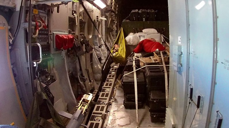 One military member finds a cozy spot to sleep in the back of the plane during the flight.