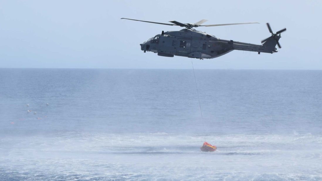 The helicopter hovers above the water during the rescue operations.