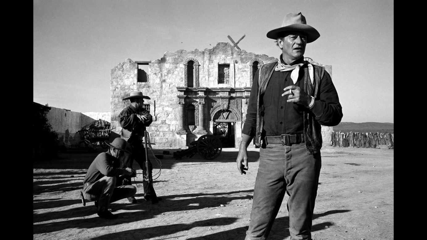 Wayne smokes on the set of "The Alamo" in 1959.