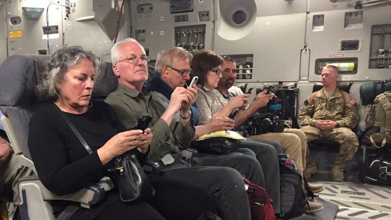 Journalists send one last email on the plane before taking off to return home.