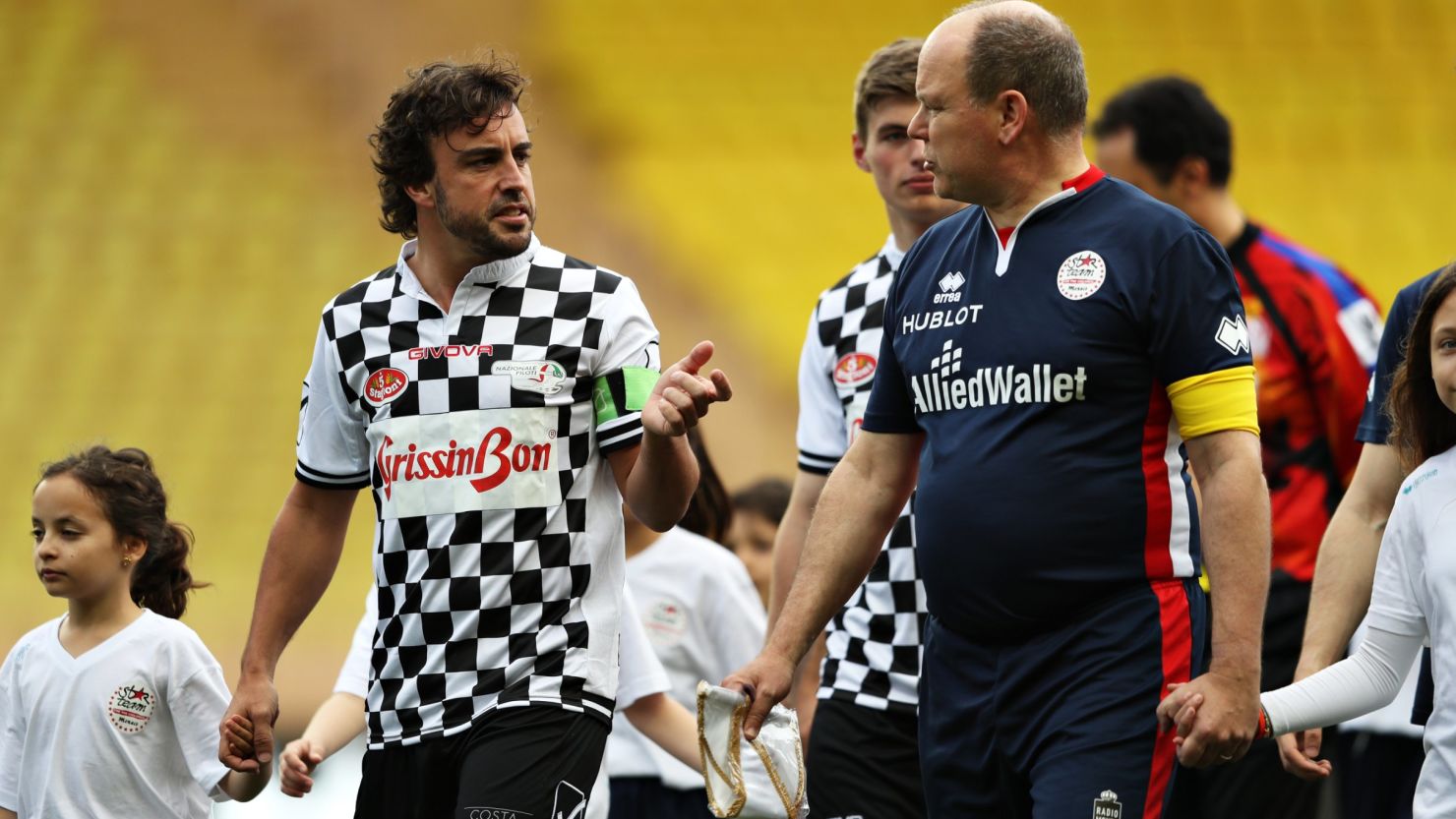 F1 star Fernando Alonso talks to Prince Albert II of Monaco as the pair lead the teams out for a charity soccer match ahead of the weekend's Monaco Grand Prix.