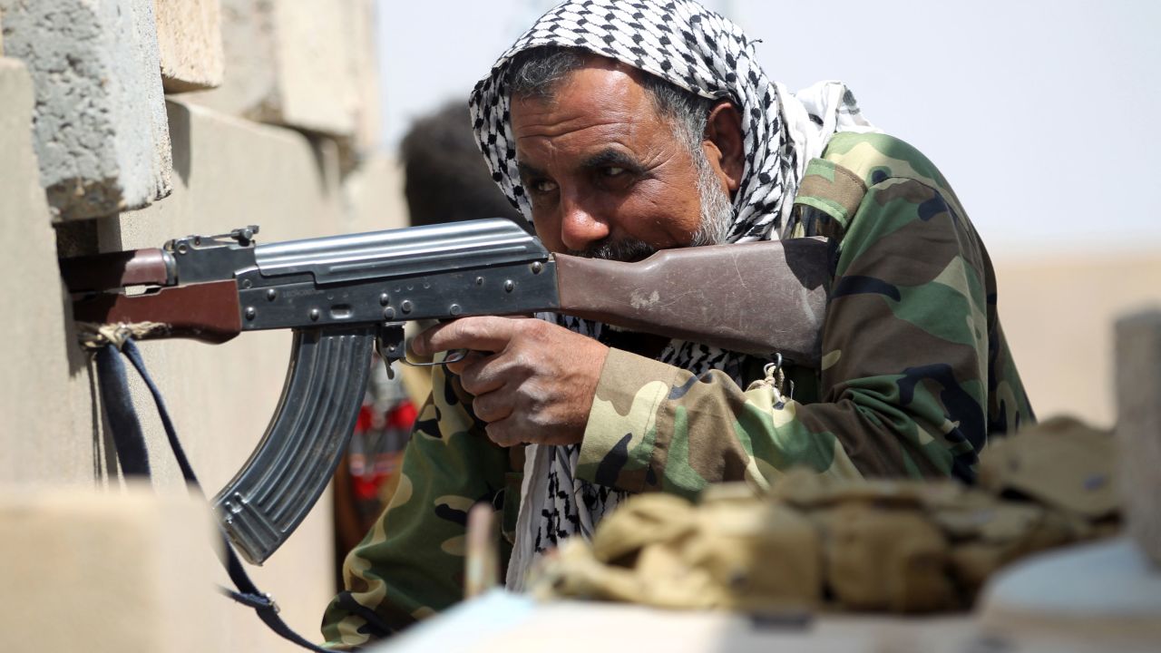 A pro-government fighter holds position in the village of al-Shahabi, east of Falluja, on Tuesday, May 24.