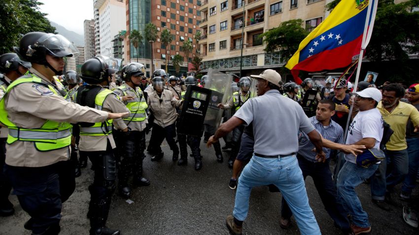 Anti-government demonstrators try to break through a barrier of Bolivarian National Police in an effort to reach the headquarters of the national electoral body, CNE, in Caracas, Venezuela, Wednesday, May 18, 2016. The opposition was blocked from marching to the CNE to demand the government allow it to pursue a recall referendum against Venezuela's President Nicolas Maduro. (AP Photo/Fernando Llano)