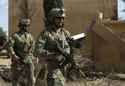 Armed men in uniform identified by Syrian Democratic Forces as U.S. special operations forces ride in truck in Raqqa province.