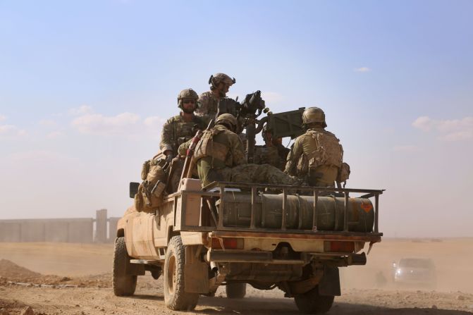 In the back of a pickup truck in the village of Fatisah in the northern Syrian province of Raqqa, armed men in uniform identified by Syrian Democratic Forces as U.S. special operations forces ride on May 25, 2016.
