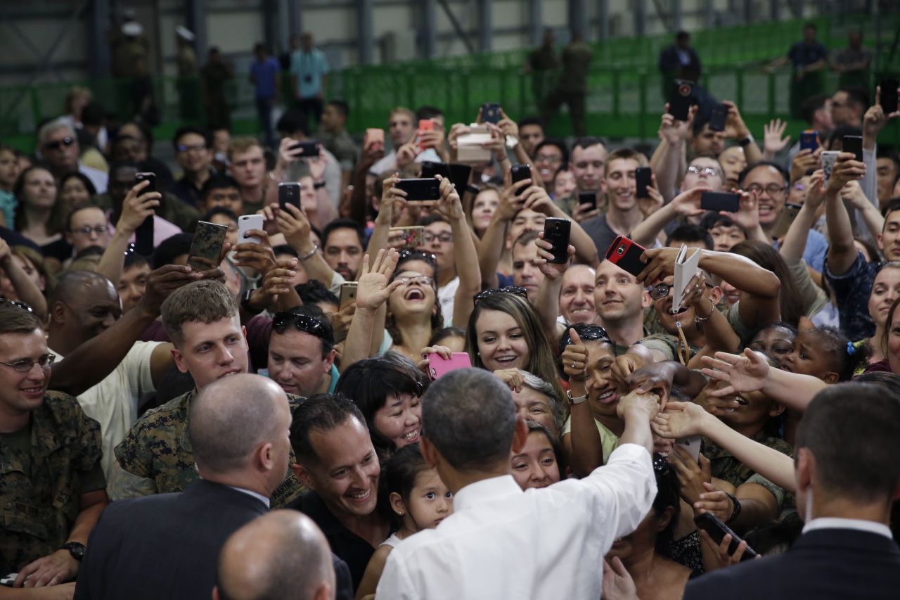 U.S. President Barack Obama, foreground center, is greeted by U.S. Marines and their families at Iwakuni air station.