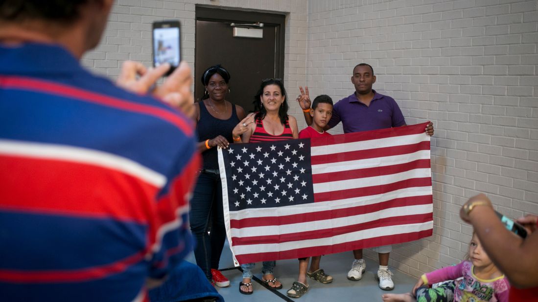 As soon as Idael Rodríguez Rivas unfurled an American flag, people rushed to have their photos taken with it. "Someone gave it to me," Rodríguez says. "Someday, I'm taking it back to Cuba with me." Here, Kenia Suarez Brunet, 39, Maria Nelys Casto Mirabal, 51, Yancarlos Rodriguez Castillo, 10, and Ismael Martinez Ramcoll, 40, pose for the camera.
