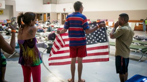 Ideal Rodriguez Rivas poses proudly with an American flag someone gave him shortly after he arrived in the United States.