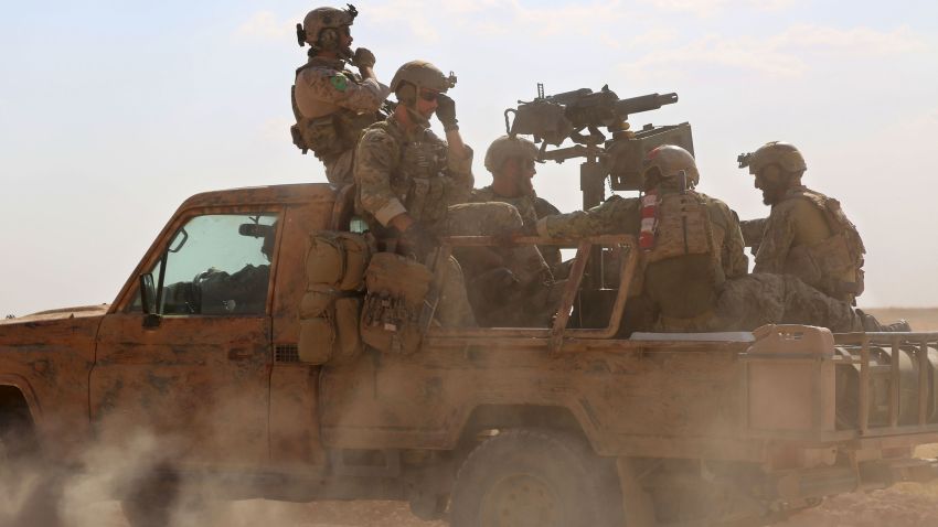 TOPSHOT - Armed men in uniform identified by Syrian Democratic forces as US special operations forces ride in the back of a pickup truck in the village of Fatisah in the northern Syrian province of Raqa on May 25, 2016. US-backed Syrian fighters and Iraqi forces pressed twin assaults against the Islamic State group, in two of the most important ground offensives yet against the jihadists. The Syrian Democratic Forces (SDF), formed in October 2015, announced on May 24 its push for IS territory north of Raqa city, which is around 90 kilometres (55 miles) south of the Syrian-Turkish border and home to an estimated 300,000 people. The SDF is dominated by the Kurdish People's Protection Units (YPG) -- largely considered the most effective independent anti-IS force on the ground in Syria -- but it also includes Arab Muslim and Christian fighters. / AFP / DELIL SOULEIMAN        (Photo credit should read DELIL SOULEIMAN/AFP/Getty Images)