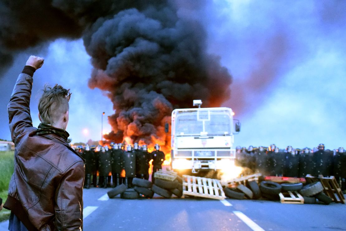 A protester defies riot police as oil refinery workers blockade a road in Douchy-Les-Mines, France, on May 25 to protest the government's proposed labor reforms.