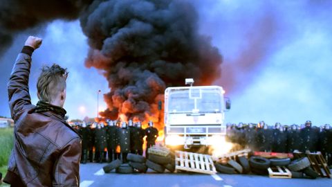 A protester defies riot police as oil refinery workers blockade a road in Douchy-Les-Mines, France, on May 25 to protest the government's proposed labor reforms.