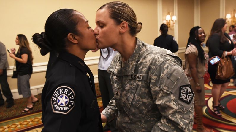 U.S. Army Sgt. Kathryn Fermin-Weinreb, right, kisses her wife, Victoria, after Victoria graduated from the Denver Sheriff Department training academy on Friday, May 13.