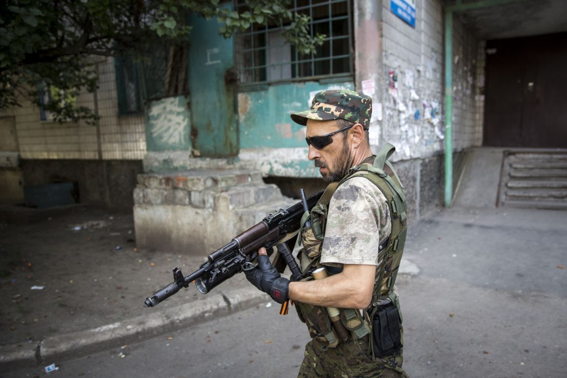 A pro-Russia rebel patrols a neighborhood near the central railway station in Donetsk, Ukraine in 2014.