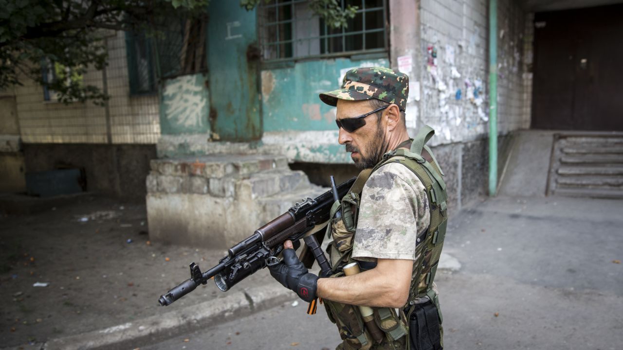 A pro-Russia rebel patrols a neighborhood near the central railway station in Donetsk, Ukraine in 2014.