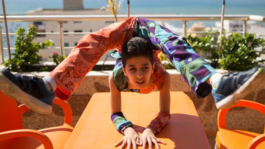 Palestinian teenager Mohammed al-Sheikh, 12, shows his skills on a table in Gaza city on April 28, 2016.
Mohammed al-Sheikh is only 12 and feels trapped in Gaza but he dreams of a Guinness world record for a series of stunning backflips and his almost unbelievable body contortions. Mohammed, just 1.37 metres (four foot, six inches) tall and weighing 29 kilograms (64 pounds), can bend his body in seemingly impossible ways, throwing his feet over his shoulders with reckless abandon or jumping into a spider-like pose. / AFP / MAHMUD HAMS        (Photo credit should read MAHMUD HAMS/AFP/Getty Images)