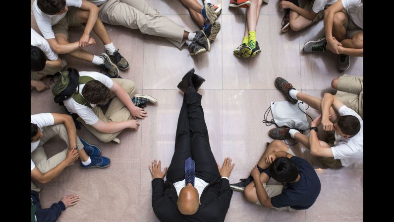 U.S. Sen. Cory Booker sits on the floor with eighth-graders visiting the Hart Senate Office Building in Washington on Tuesday, May 24.