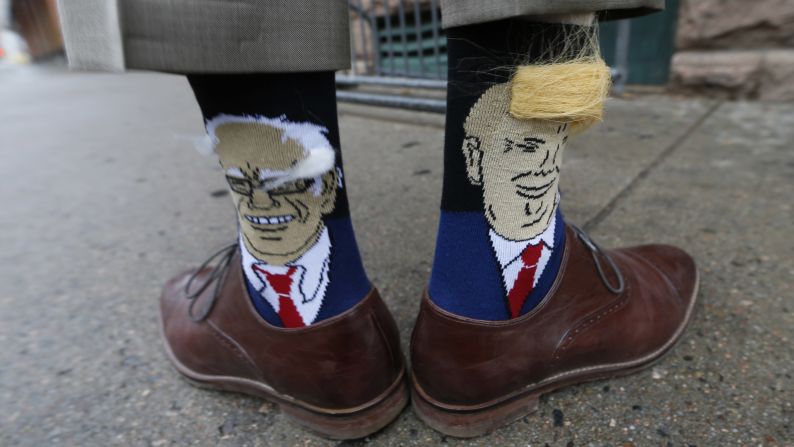 Colorado Gov. John Hickenlooper shows off his socks -- one with Democratic presidential candidate Bernie Sanders, left, and the other with Republican candidate Donald Trump -- before signing copies of his autobiography in Denver on Thursday, May 26.  