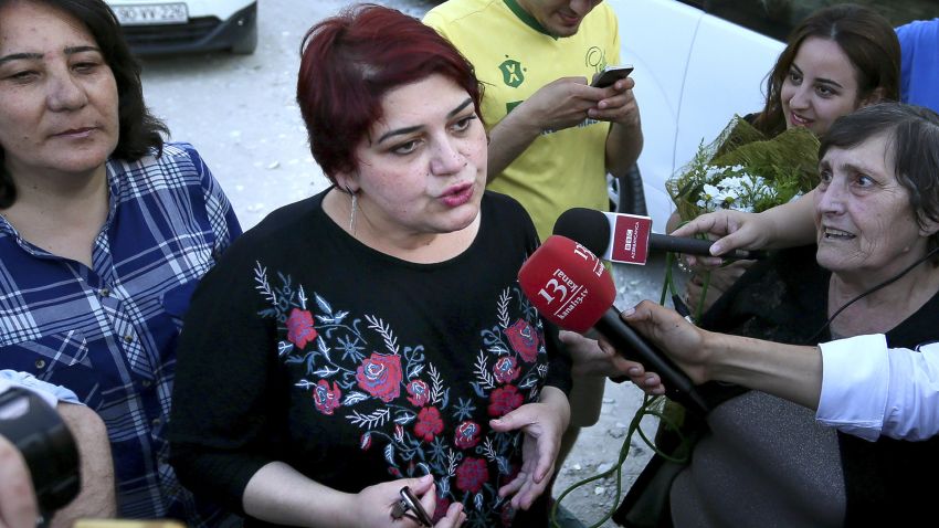 Azeri Khadija Ismayilova, center, a reporter for Radio Free Europe/Radio Liberty, who has become a symbol of defiance, praised by human rights and free-speech organizations around the world, speaks to journalists right after she has been released in Baku, Azerbaijan, Wednesday, May 25, 2016. A prominent, award-winning Azerbaijani journalist has been released on probation following a storm of international protests about her imprisonment. (AP Photo/ Aziz Karimov)