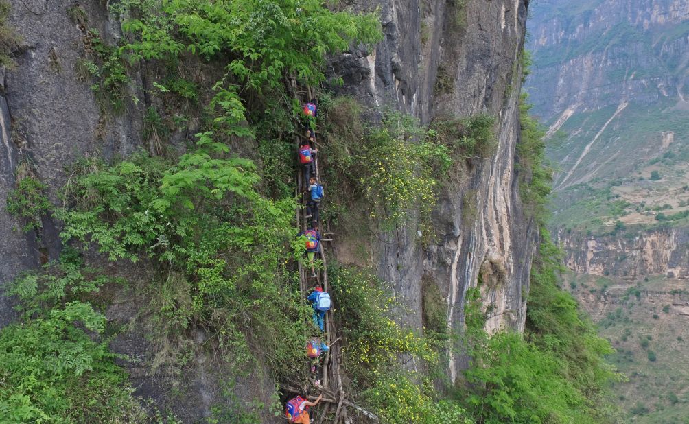 Children in Atule'er, a village in China's Sichuan province, climb a cliff to reach their school.