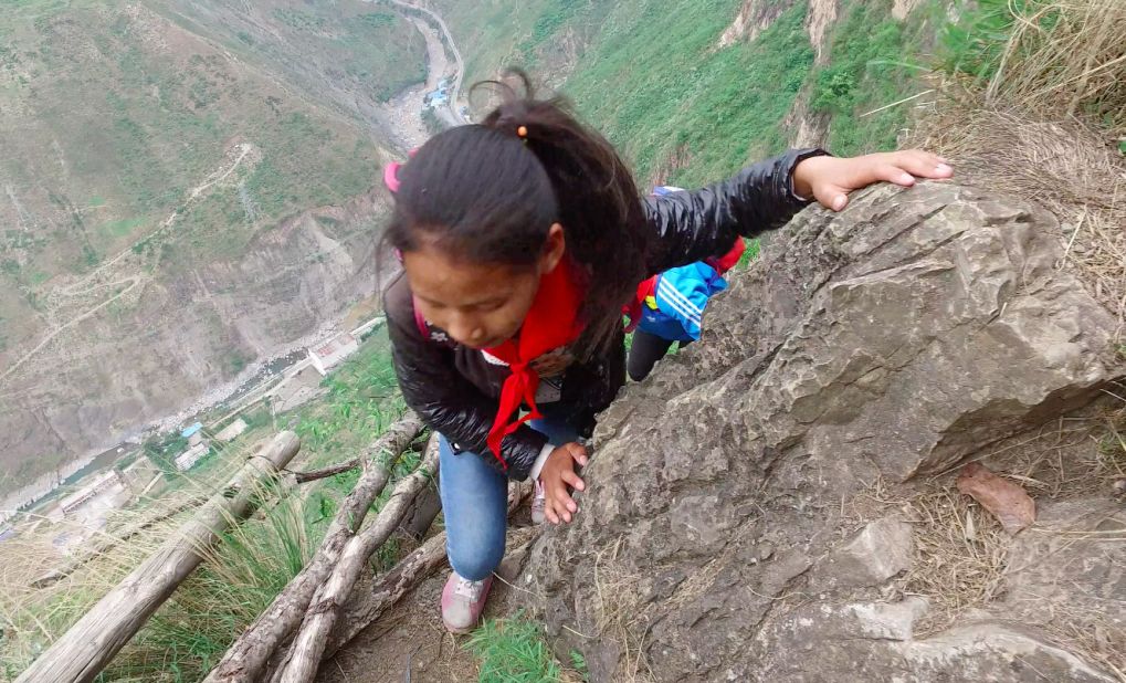 The children spend roughly two hours on each trip up or down the cliff. The trip is so demanding they go home twice a month, the photographer says.