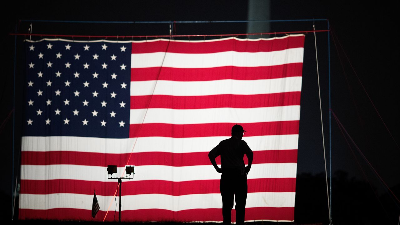 A man stands in front of a large American flag set up on the National Mall in Washington on May 27.