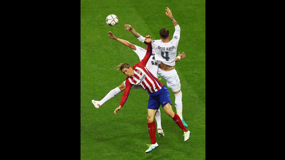 Fernando Torres of Atletico Madrid is challenged by Real Madrid's Sergio Ramos and Pepe. 