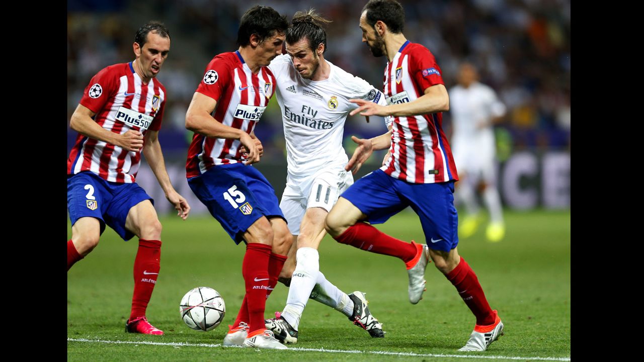 Real Madrid's Gareth Bale tries to maintain control of the ball while driving through some Atletico players. 