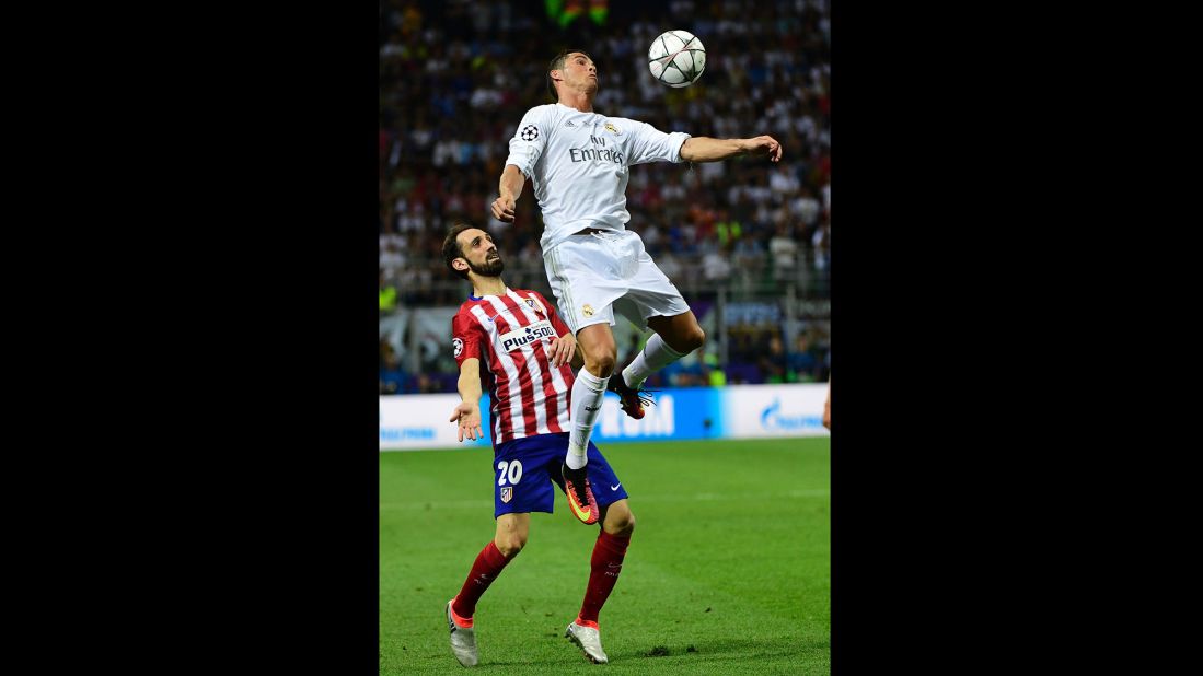 Real Madrid forward Cristiano Ronaldo heads the ball next to Atletico Madrid defender Juanfran.  