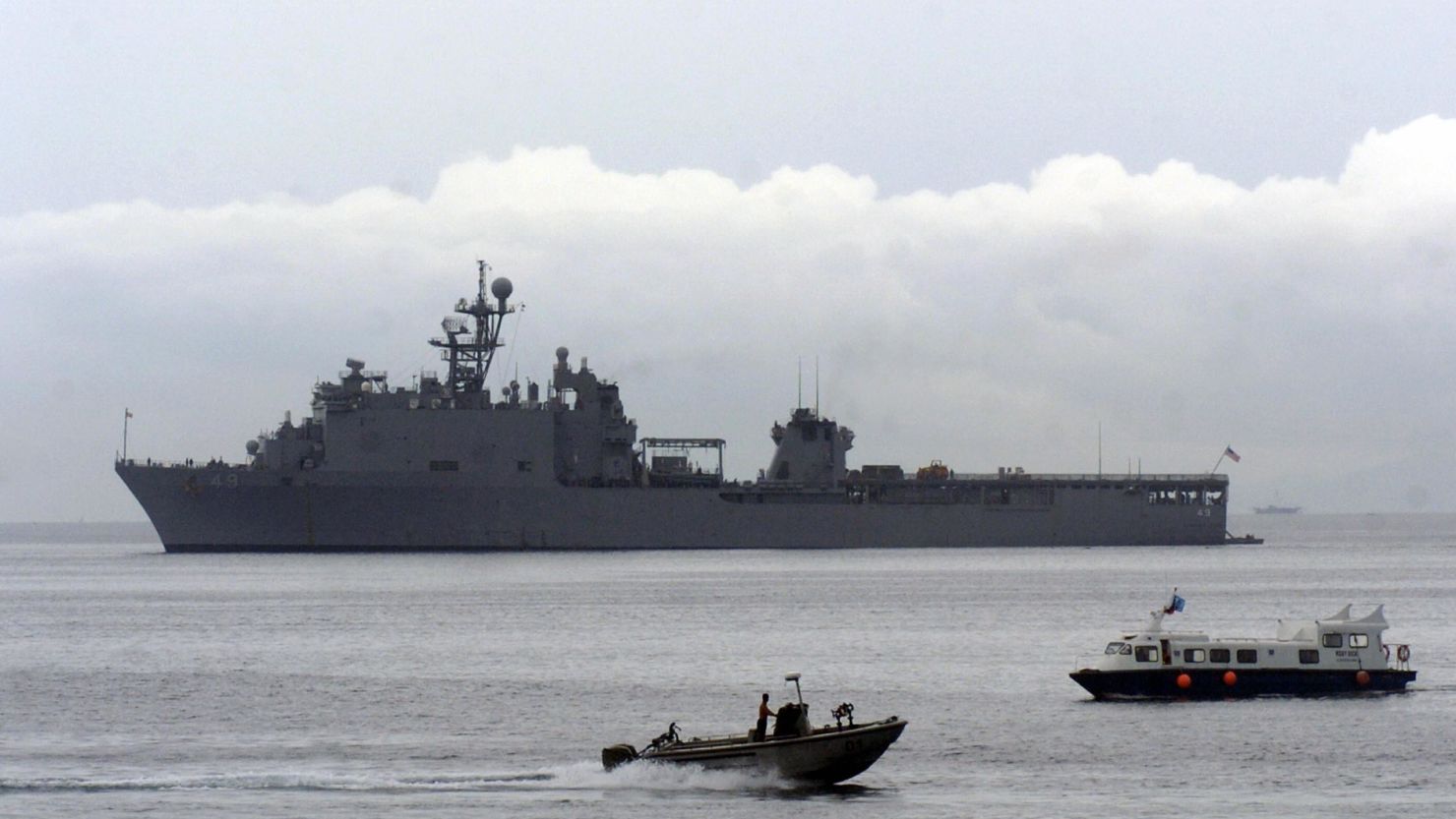 Local boats pass beside USS Harpers Ferry in the southern Philippines on May 30, 2007.