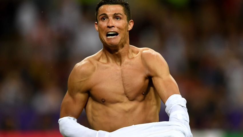 MILAN, ITALY - MAY 28:  Cristiano Ronaldo of Real Madrid takes off his shirt in celebration after scoring the winning penalty in the penalty shoot out during the UEFA Champions League Final match between Real Madrid and Club Atletico de Madrid at Stadio Giuseppe Meazza on May 28, 2016 in Milan, Italy.  (Photo by Laurence Griffiths/Getty Images)