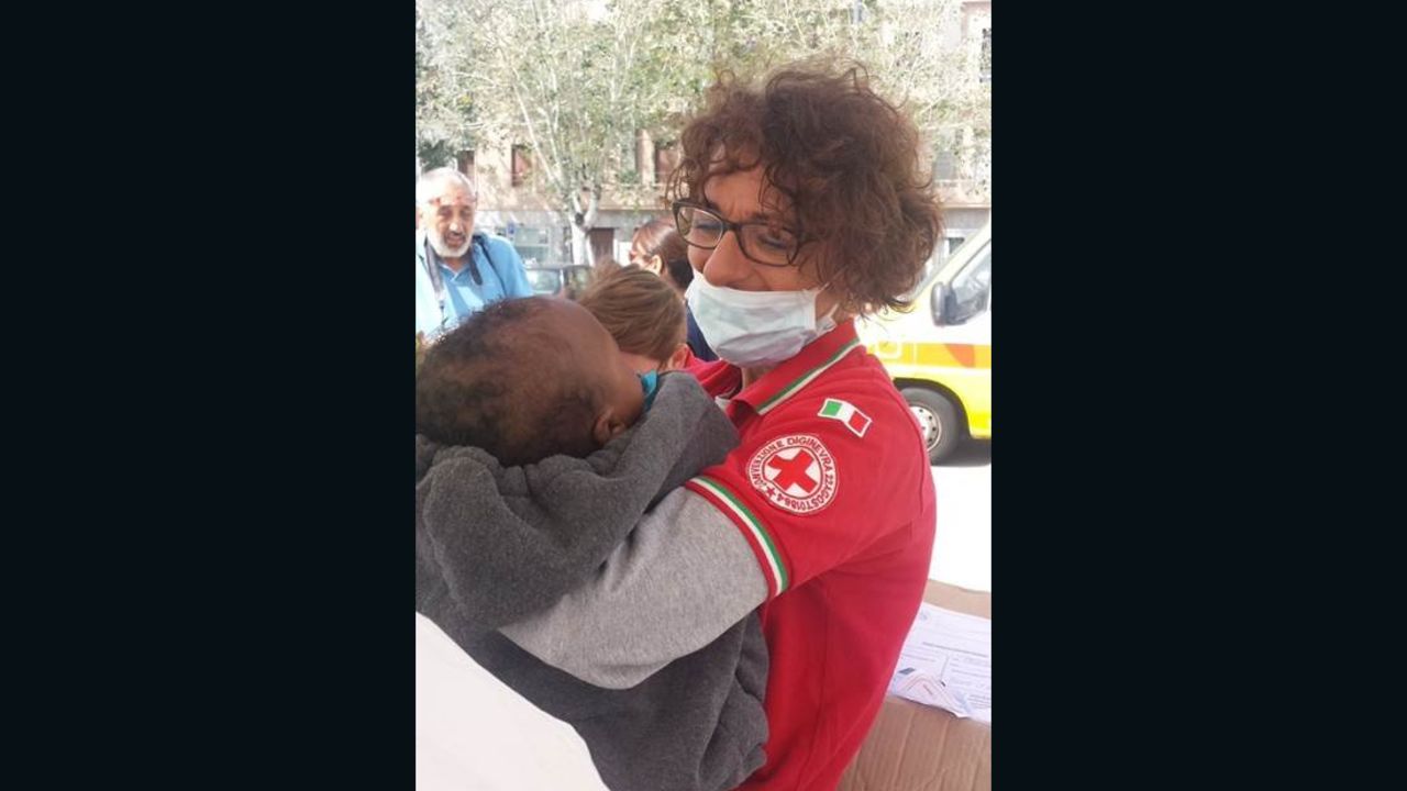 An Italian Red Cross worker holds a rescued migrant baby who arrived in Messina, Italy. 