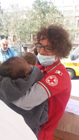 An Italian Red Cross worker holds a rescued migrant baby who arrived in Messina, Italy. 