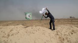 A policeman places an Iraqi federal police flag next to a Shiite Popular Mobilization Forces flag outside Falluja on May 28.