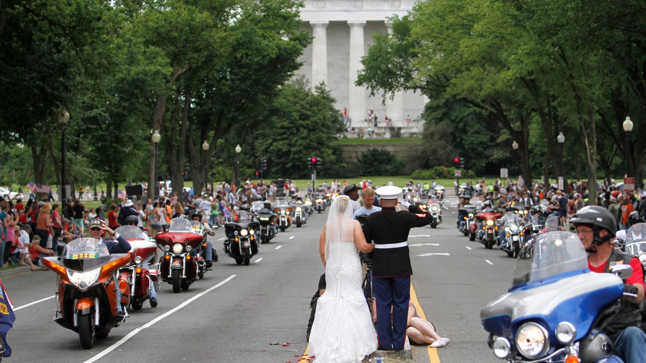 Retired Marine Staff Sgt. Tim Chambers and his new wife, Lorraine, salute riders during the Rolling Thunder event.