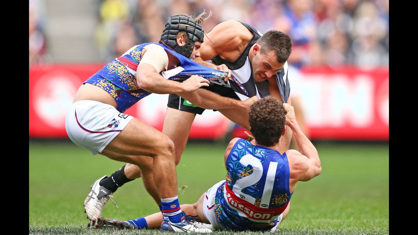 A couple of the Western Bulldogs tackle Levi Greenwood of the Collingwood Magpies during an Australian Football League match on Sunday, May 29.