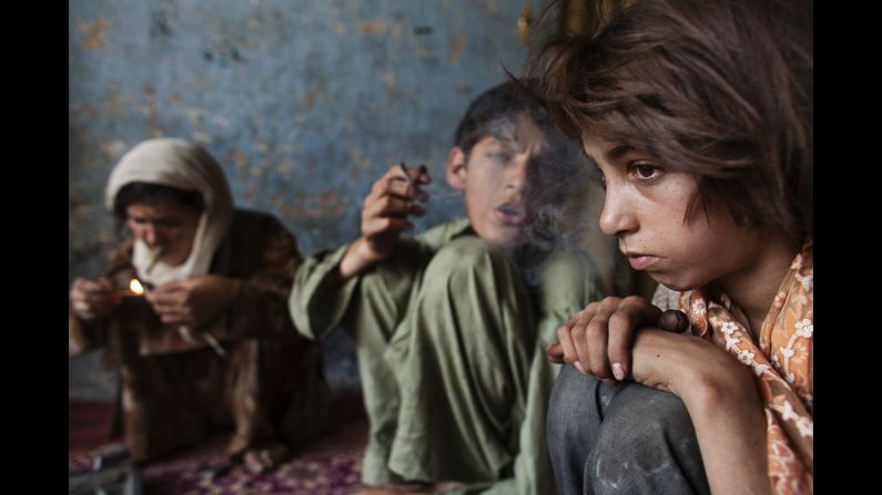 Gulparai, 11, sits next to her brother and mother as they use heroin in August 2007.