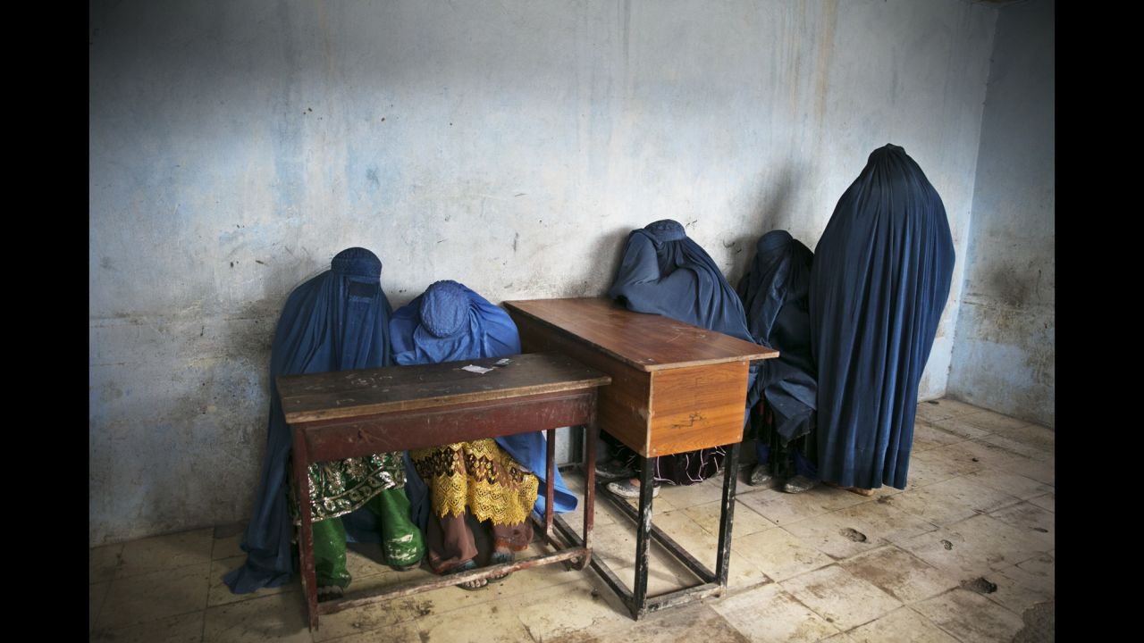 Burqa-clad women wait to vote after ballot papers ran out at a polling station in Kabul in April 2014.